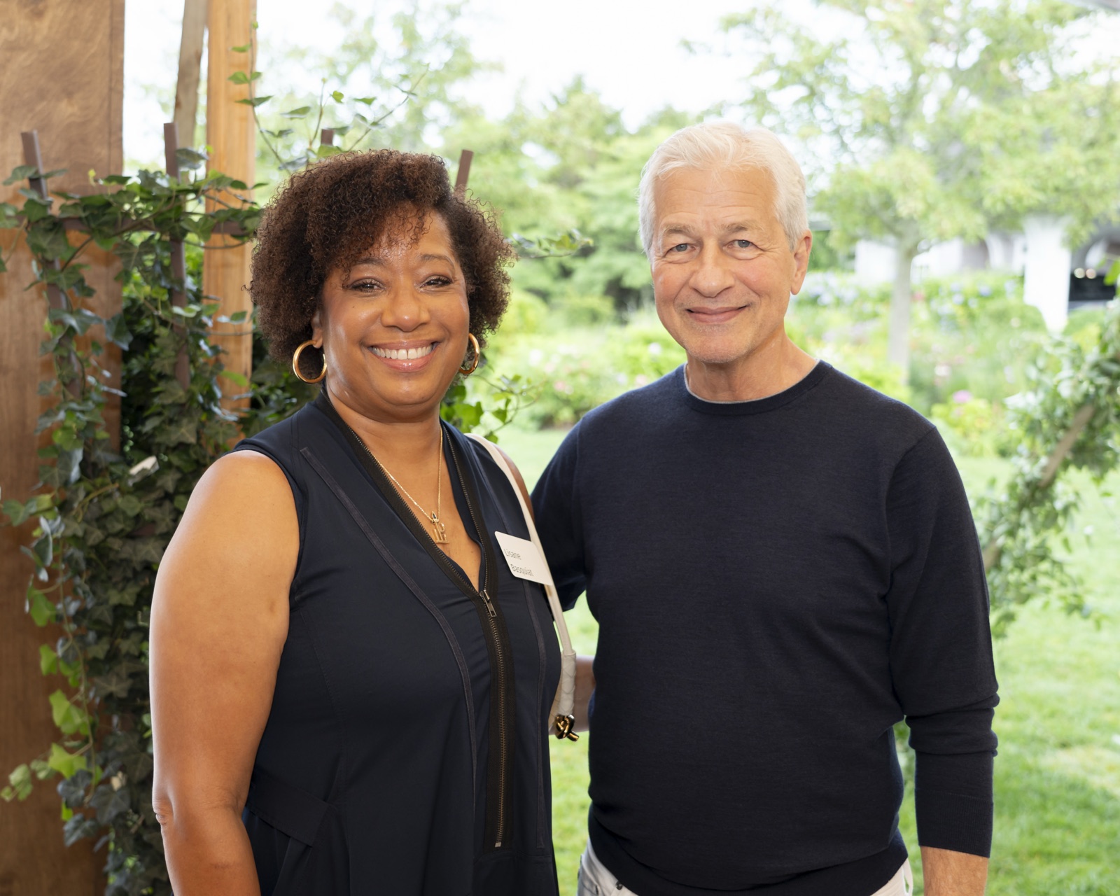 Lisane Basquiat with Jamie Dimon, Chairman and Chief Executive Officer of JPMorgan Chase, smiling together at an outdoor event