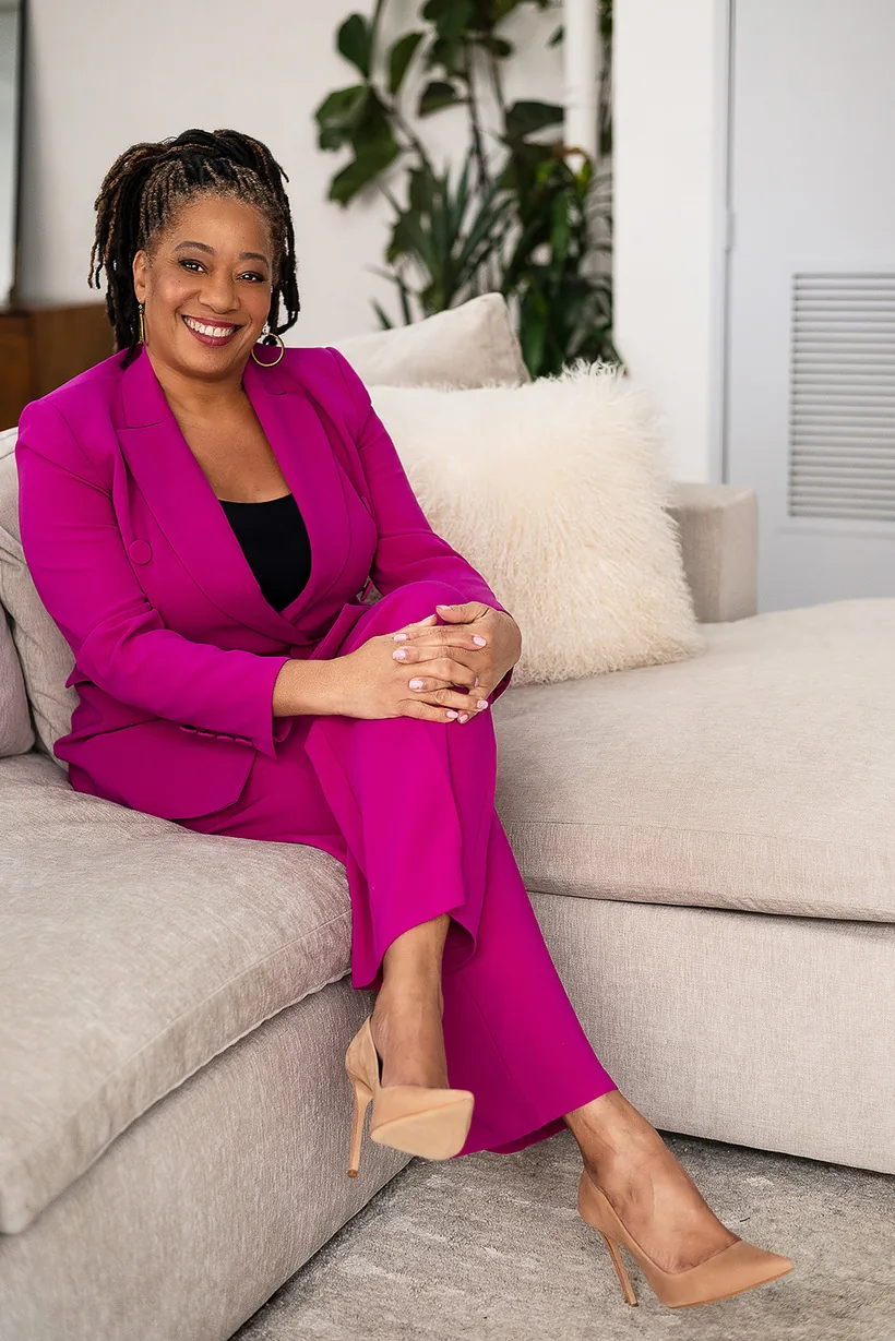 Lisane Basquiat seated in a fuchsia suit