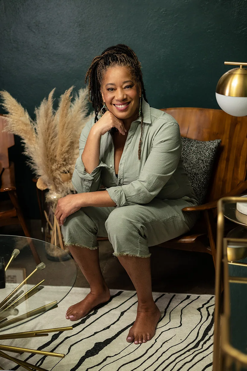 Lisane Basquiat seated in a sage outfit in a lounge setting